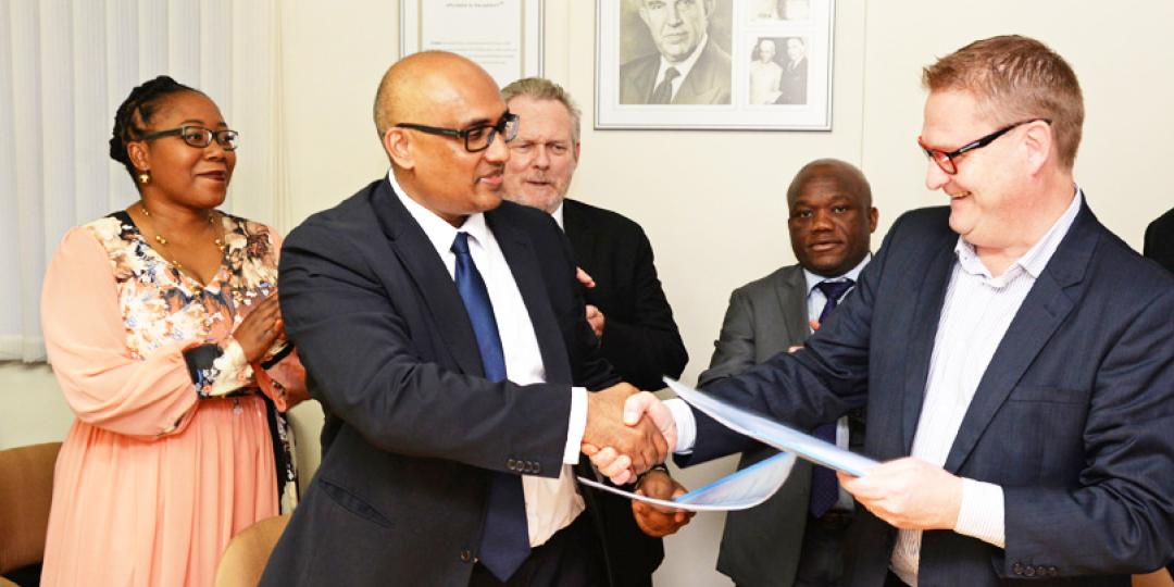 CEO of Dube Trade Port, Hamish Erskine and CEO of Cipla Biotec South Africa, Divian Govender, shake hands after the signing. In the background from left to right is Dr. Bridgette Gasa, chairperson of Dube TradePort Corporation, Rob Davies, Minister of Trade and Industry and Sihle Zikalala, KwaZuluNatal MEC for Economic Development, Tourism, and Environmental Affairs. 