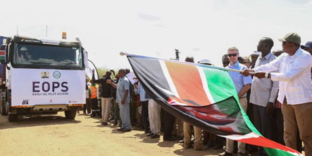 Bystanders wave the Kenyan flag upon arrival at the Port of Mombasa of the first shipment of Kenyan crude.